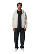 Modelo vistiendo sudadera con cremallera Fear of God Essentials en color piedra jaspeado de One Kickz