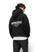 Modelo de espaldas vistiendo sudadera negra One Kickz Represent Owners Club con logo blanco y capucha de ajuste amplio
