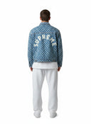 One Kickz Chaqueta vaquera trucker Supreme con agujeros en azul claro, con estampado integral y logo de Supreme en la espalda.