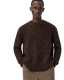 Modelo vistiendo jersey de punto grueso AllSaints Chainy en color marrón oscuro con bordado de One Kickz