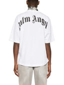 Hombre vistiendo camiseta blanca de algodón One Kickz Palm Angels con logo curvo negro desgastado en la espalda