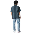 Vista trasera de una camiseta negra lavada de One Kickz con costura central, combinada con vaqueros azules