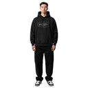 Hombre vistiendo sudadera negra Corteiz Alcatraz V2 con logo ovalado en el pecho y pantalones negros a juego