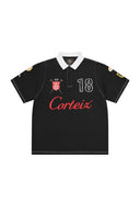Polo One Kickz Corteiz Alpine negro con cuello blanco, bordados gráficos y número 18 en el pecho.