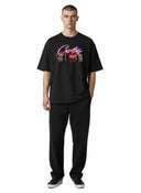 Camiseta negra One Kickz Corteiz No Time 4 Luv con estampado gráfico de dinamita y logo rosa en el pecho