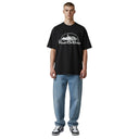Modelo vistiendo camiseta negra Corteiz Kingdom Tee con estampado gráfico blanco, combinada con jeans azules