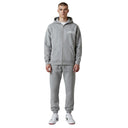 Modelo vistiendo sudadera con cremallera y pantalones de chándal One Kickz Corteiz Island en color gris jaspeado