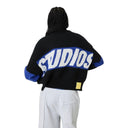 Modelo de espaldas vistiendo el jersey Eme Studios Thrill Sodalite R9 negro y azul con logo grande en One Kickz