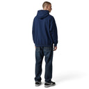 Hombre de espaldas vistiendo sudadera con capucha azul marino Fear of God Essentials NBA y pantalones vaqueros oscuros