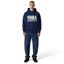 Hombre vistiendo sudadera con capucha azul marino Fear of God Essentials NBA con logo estampado en el pecho