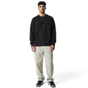 Modelo vistiendo suéter negro de punto Supreme Flocked Logo de One Kickz con pantalones claros y zapatillas