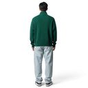 Vista trasera de un modelo vistiendo un suéter de punto acanalado verde con cremallera de One Kickz