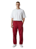 Pantalón de chándal rojo Supreme Umbro con detalles de pedrería, lucido por un modelo con camiseta blanca